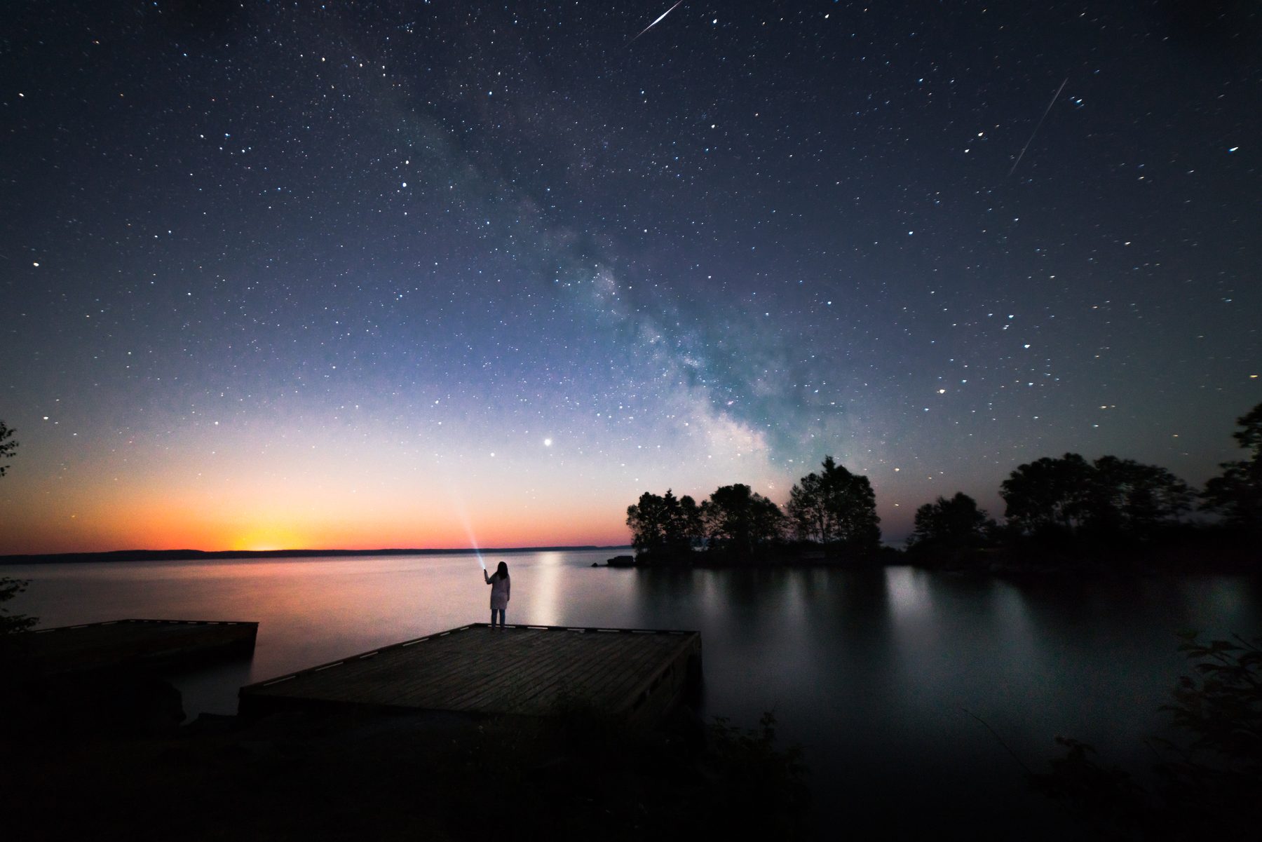 The Milky Way and a meteor over the dock at dusk