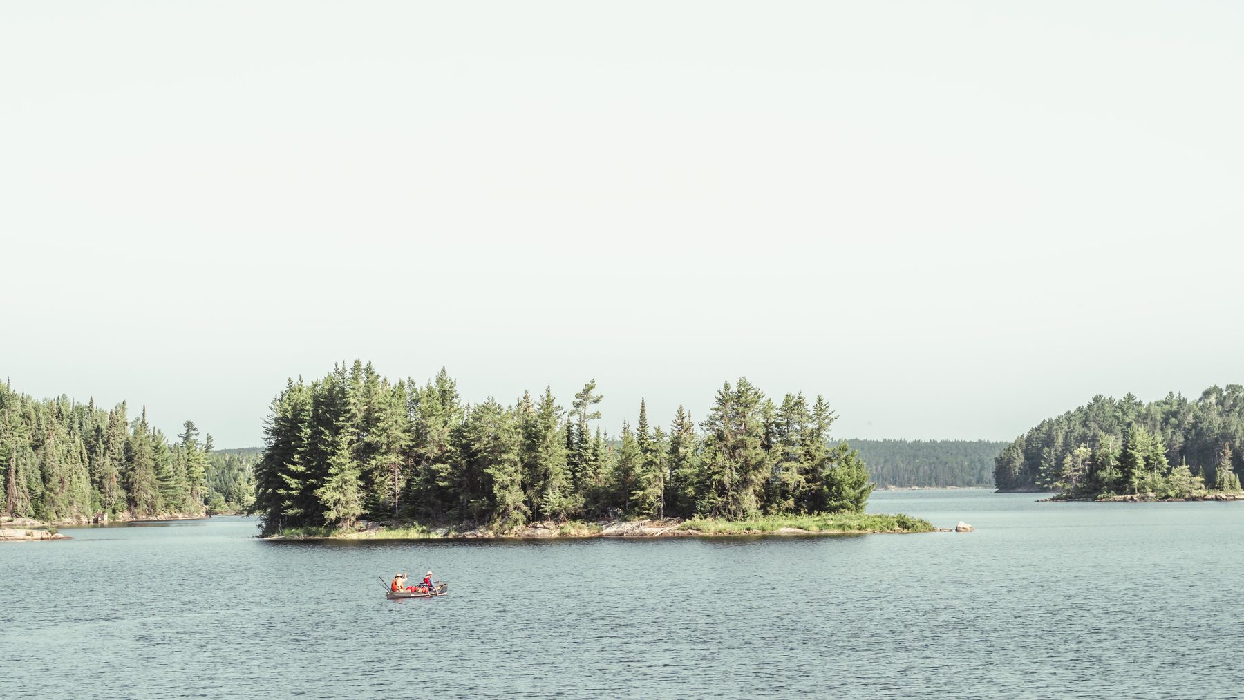 Paddlers passing an island in the pale morning